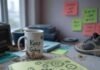 Growth Mindset Examples You Can Apply at Work and Life Messy desk with notebook, mug, sneaker, sticky notes.